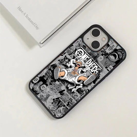 Phone case featuring a full-color Gear 5 Luffy sitting playfully in front of a detailed black and white One Piece manga panel background.